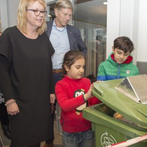 Kinderen  halen brood uit de container om aan de broodvergister te voeren